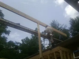 Carpenter setting a ridge beam over a new addition frame — Ice Dam Removal by Roofing Brothers in Exeter